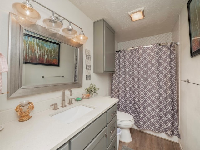 bathroom featuring vanity, toilet, curtained shower, a textured ceiling, and hardwood / wood-style floors