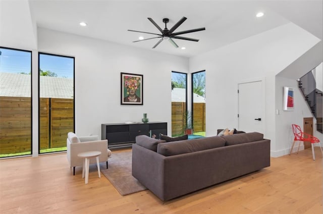 living room featuring ceiling fan, light hardwood / wood-style flooring, and a wealth of natural light