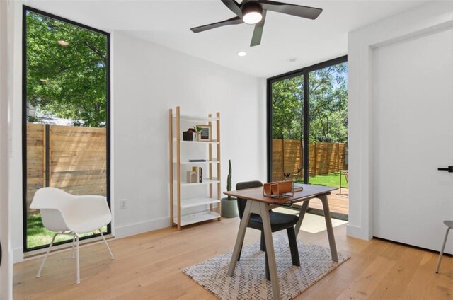 office area with floor to ceiling windows, light wood-type flooring, and plenty of natural light