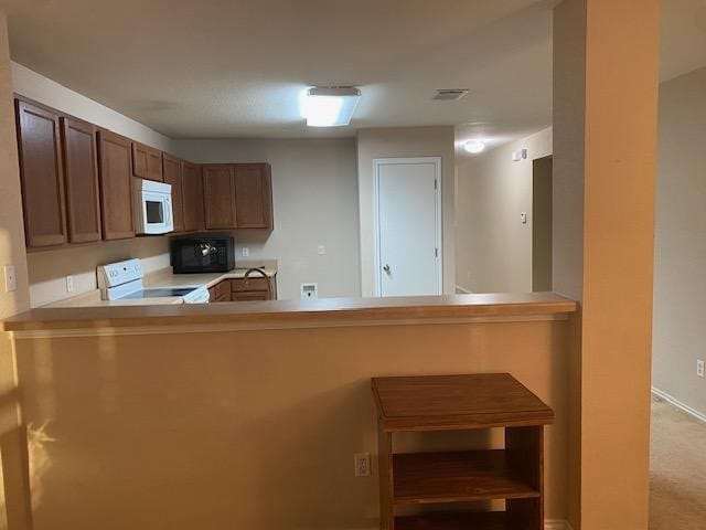 kitchen with kitchen peninsula and white appliances