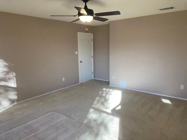 carpeted spare room featuring ceiling fan