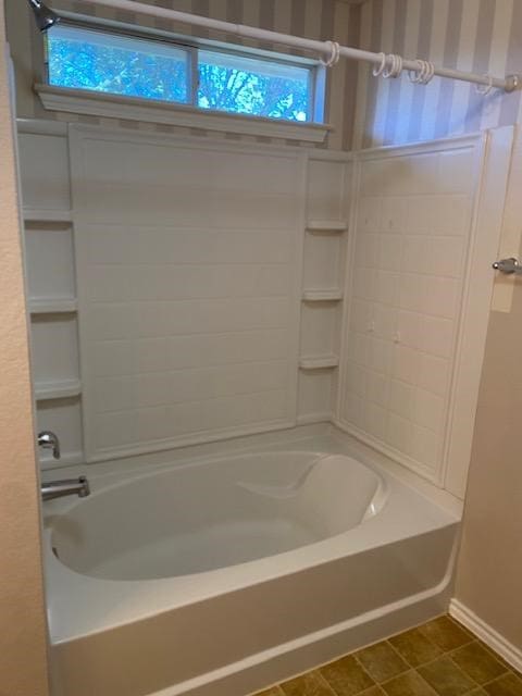 bathroom with tile patterned flooring and bathing tub / shower combination