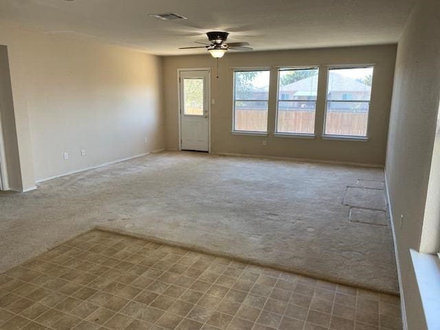 spare room with ceiling fan and light carpet