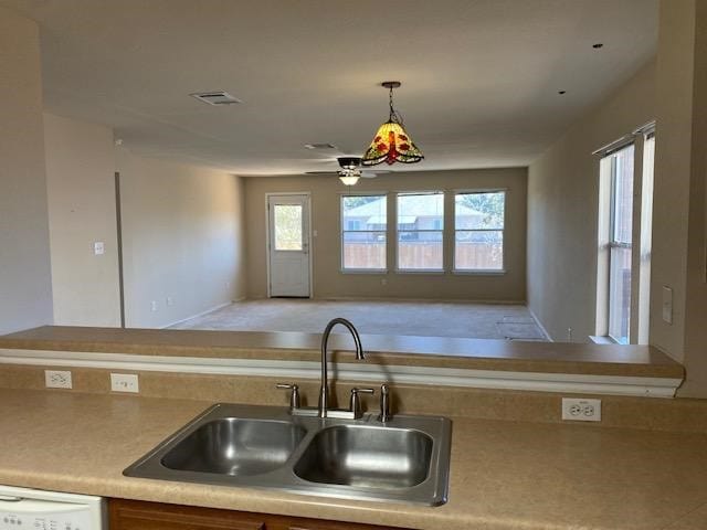 kitchen featuring decorative light fixtures, white dishwasher, ceiling fan, and sink