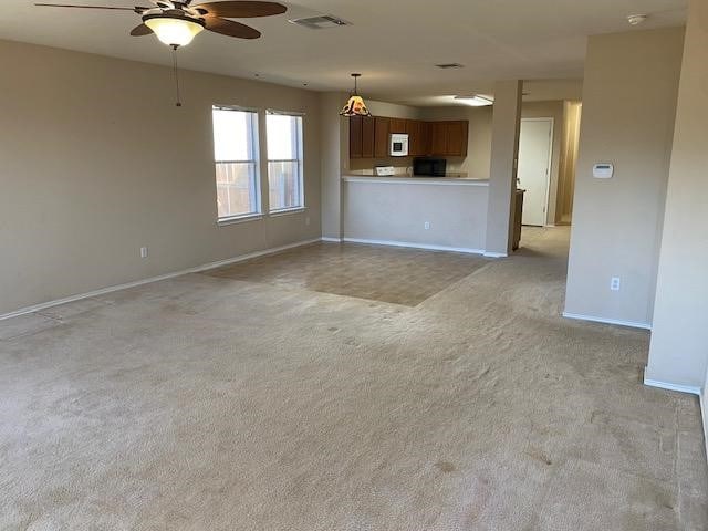 unfurnished living room featuring ceiling fan and light carpet