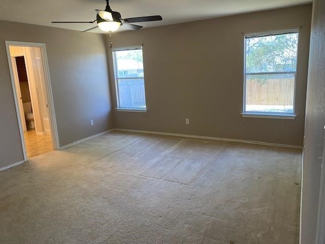 carpeted spare room featuring ceiling fan