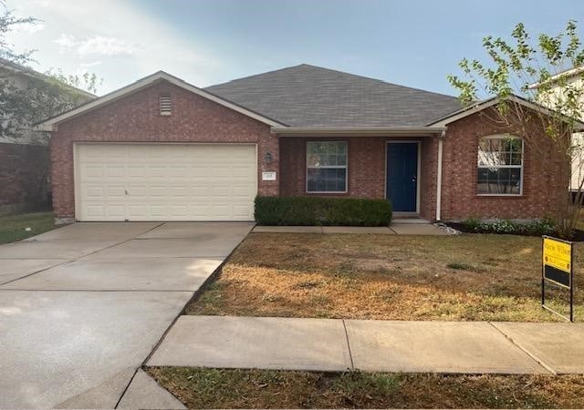 single story home with a garage and a front lawn