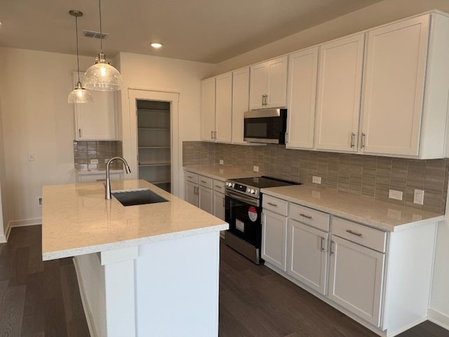 kitchen featuring stainless steel appliances, dark wood-style flooring, a sink, and a kitchen island with sink