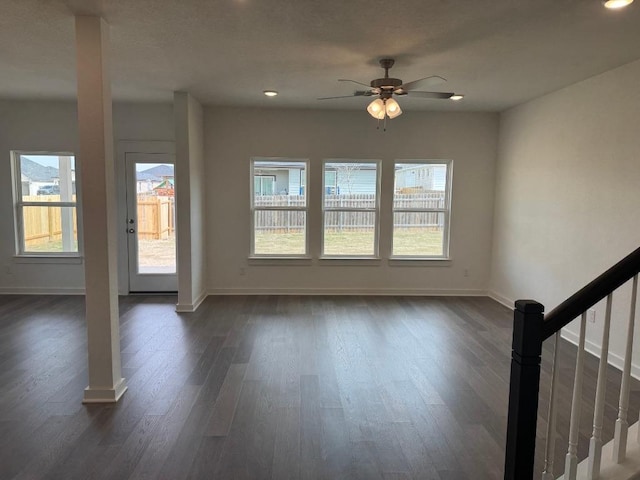 unfurnished living room featuring dark wood-style floors and baseboards