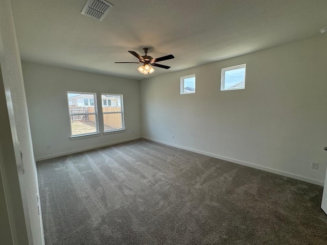 carpeted spare room featuring ceiling fan, a textured ceiling, visible vents, and baseboards