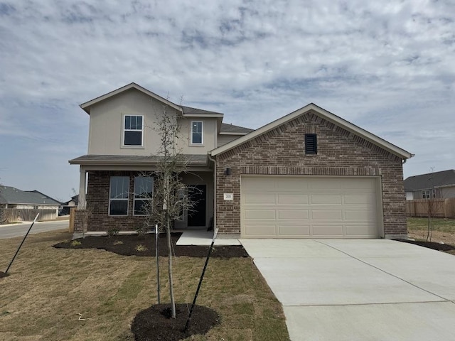 traditional home with brick siding, driveway, an attached garage, and fence