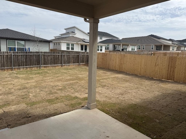 view of yard with a residential view, fence, and a patio