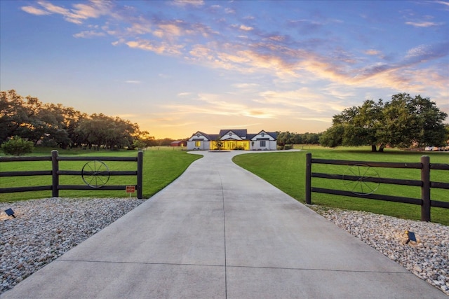 gate at dusk featuring a yard