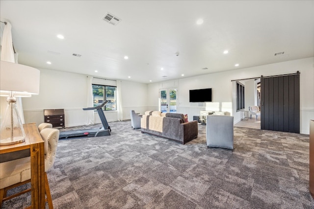 living room featuring a barn door and carpet flooring