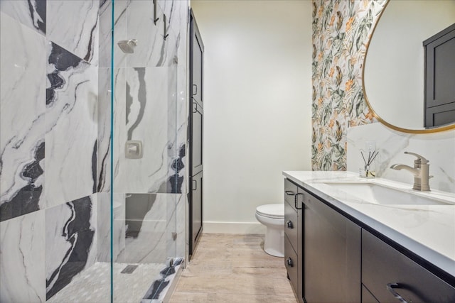 bathroom featuring wood-type flooring, vanity, toilet, and an enclosed shower