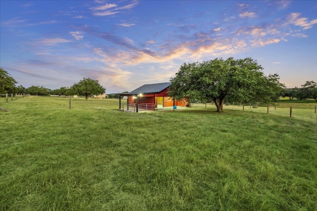 yard at dusk with an outbuilding and a rural view