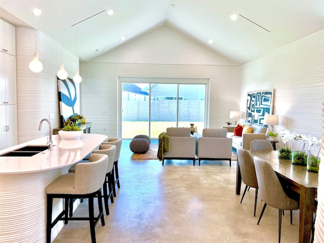 dining space with sink and vaulted ceiling