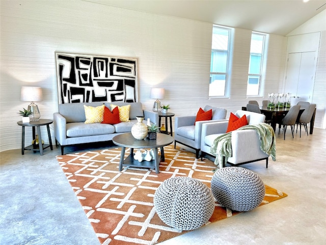 living room with vaulted ceiling and concrete flooring