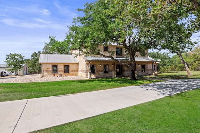 view of front facade featuring a storage shed and a front yard