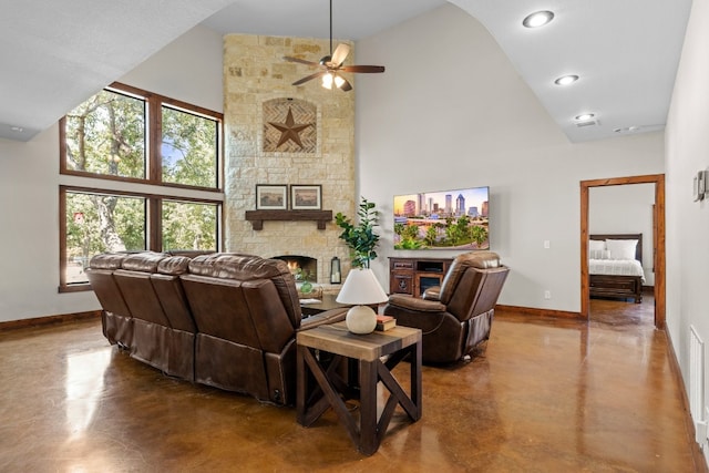 living room with a stone fireplace, ceiling fan, concrete flooring, and high vaulted ceiling