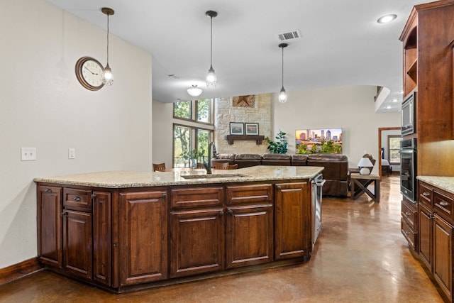 kitchen featuring light stone countertops, concrete flooring, pendant lighting, and a stone fireplace