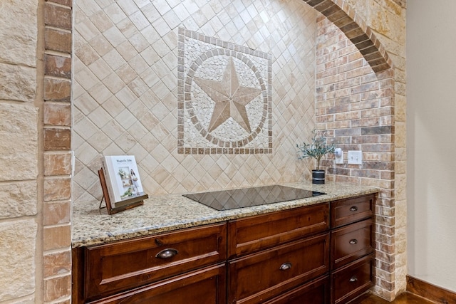 interior space with black electric cooktop and light stone countertops