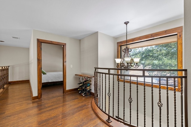 hallway with a notable chandelier and dark hardwood / wood-style flooring