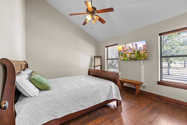 bedroom featuring vaulted ceiling, multiple windows, dark hardwood / wood-style floors, and ceiling fan