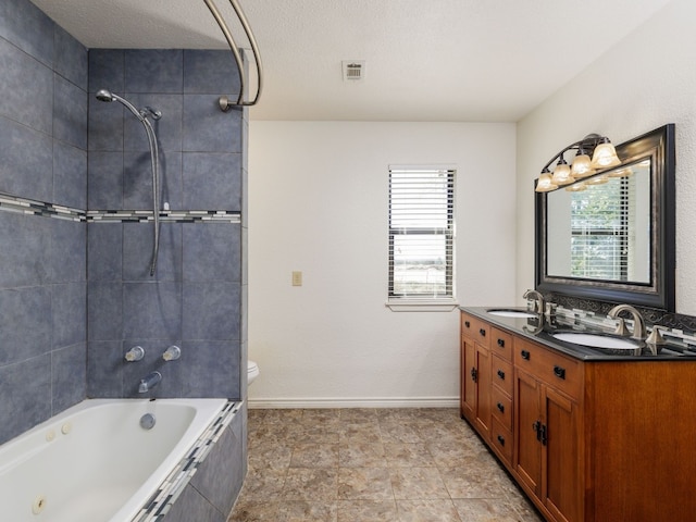 full bathroom featuring tiled shower / bath combo, vanity, toilet, and a wealth of natural light