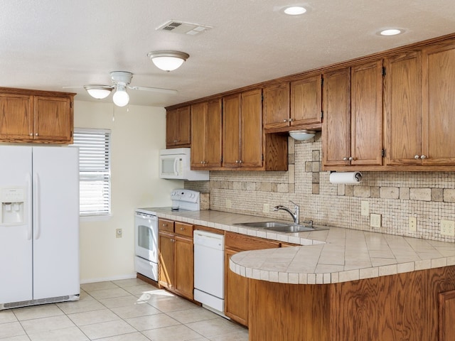 kitchen with sink, decorative backsplash, white appliances, tile countertops, and ceiling fan