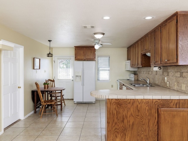 kitchen with ceiling fan, sink, kitchen peninsula, white appliances, and backsplash