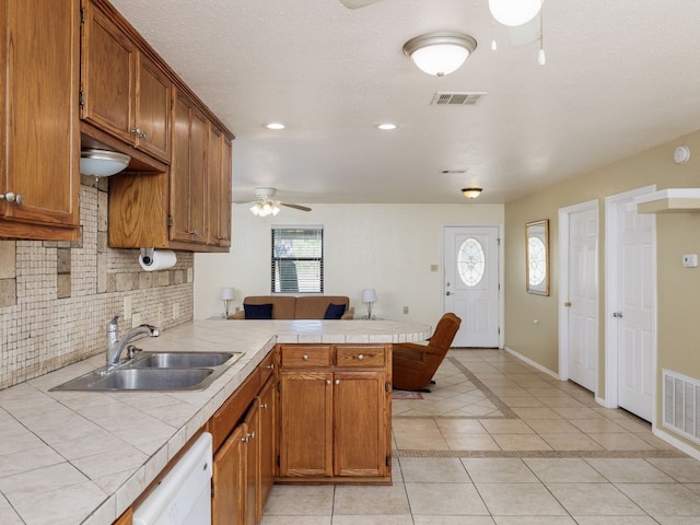 kitchen featuring kitchen peninsula, sink, ceiling fan, and plenty of natural light