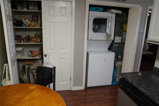 clothes washing area featuring stacked washer and dryer and dark wood-type flooring