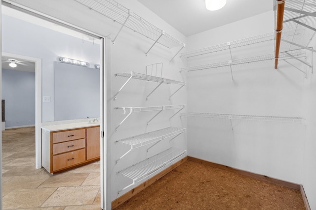 walk in closet with ceiling fan