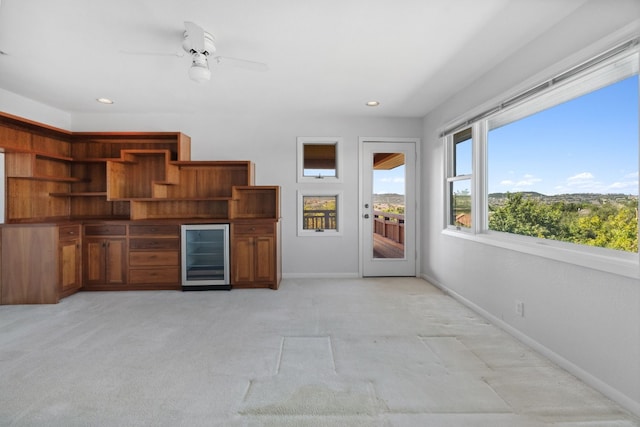 interior space featuring ceiling fan, light carpet, and beverage cooler