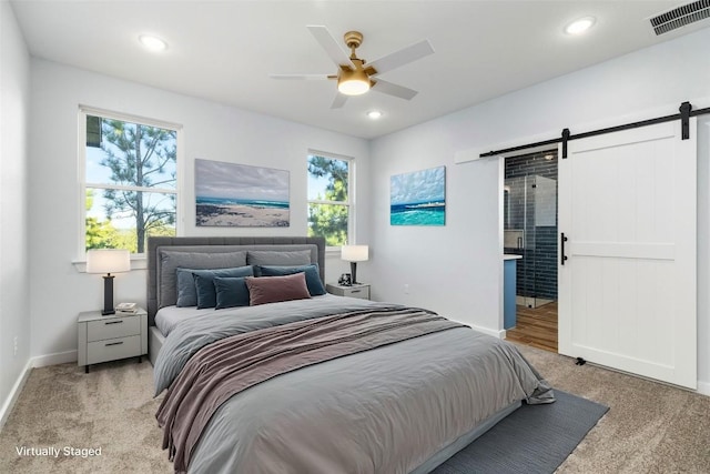 carpeted bedroom with multiple windows, a barn door, and ceiling fan