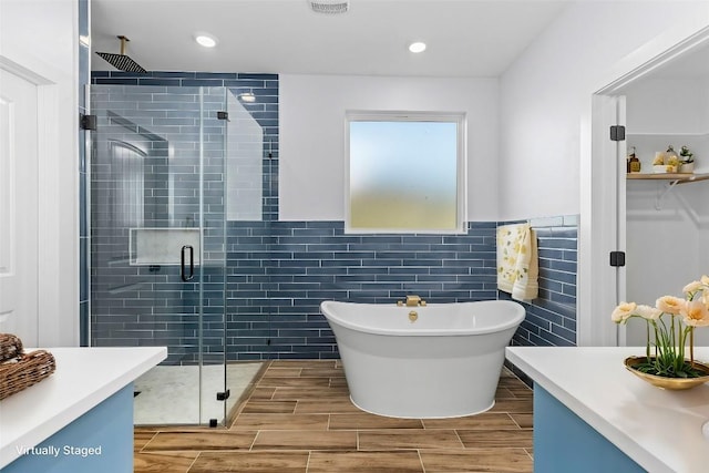 bathroom featuring a freestanding tub, tile walls, vanity, wood tiled floor, and a stall shower