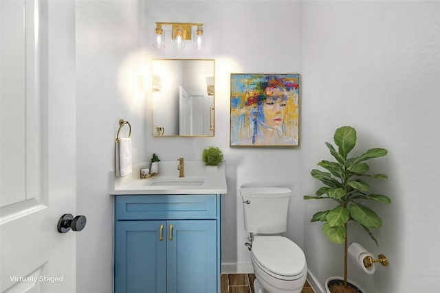 bathroom with hardwood / wood-style floors, vanity, and toilet