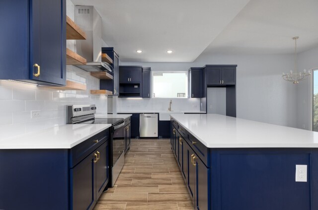 kitchen featuring blue cabinetry, appliances with stainless steel finishes, and a wealth of natural light