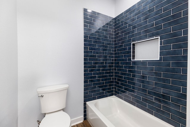 bathroom featuring hardwood / wood-style flooring, toilet, and tiled shower / bath