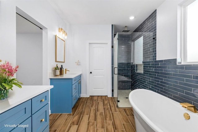 bathroom featuring vanity, wood-type flooring, and independent shower and bath