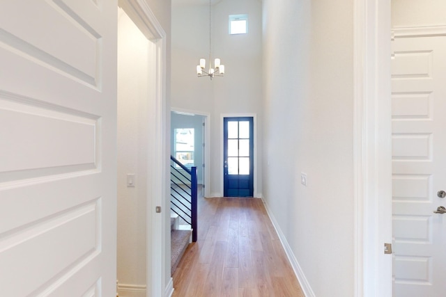 entrance foyer with a chandelier, light hardwood / wood-style floors, and a high ceiling