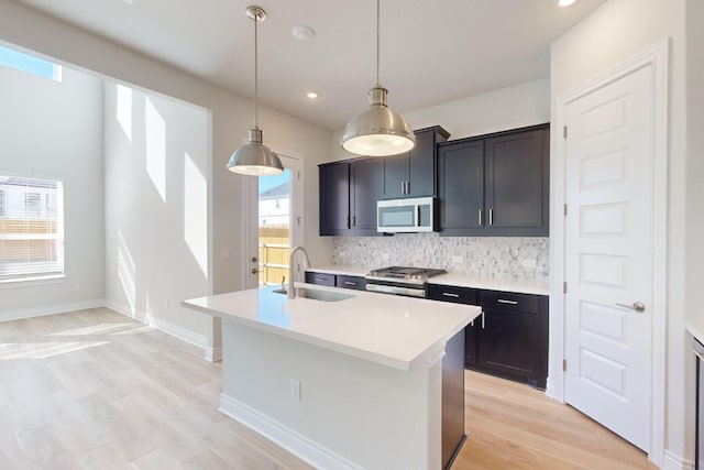 kitchen featuring plenty of natural light, an island with sink, stainless steel appliances, and sink