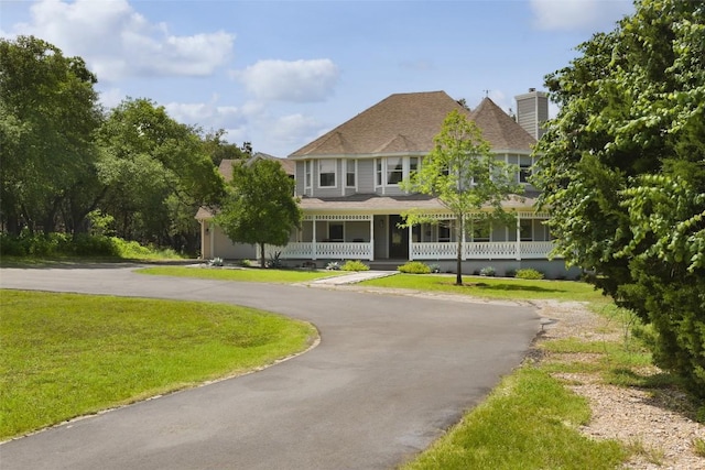 11505 SW Oaks, Austin, TX 78737 - victorian-style house featuring a porch, curved driveway, a front lawn, and a chimney