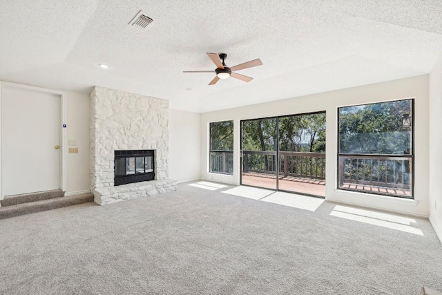 unfurnished living room featuring a fireplace, ceiling fan, a textured ceiling, and light carpet