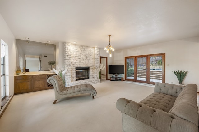 carpeted living room featuring a notable chandelier and a fireplace