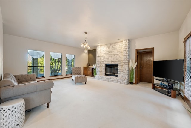 carpeted living room with a brick fireplace and a chandelier