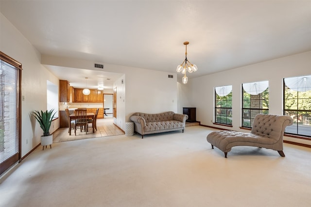 carpeted living room featuring a notable chandelier