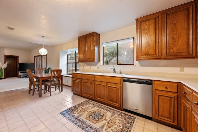 kitchen with decorative backsplash, dishwasher, pendant lighting, a textured ceiling, and sink