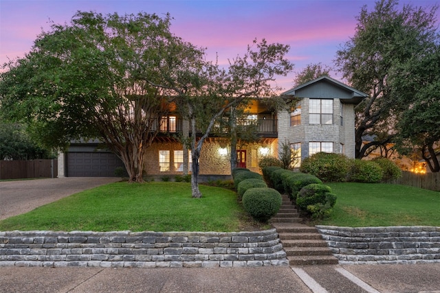 view of front of property featuring a lawn and a balcony